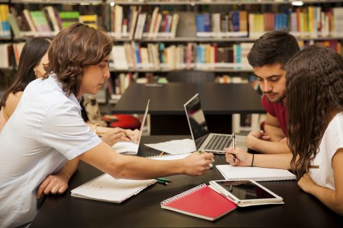Group of college students working together in the school library